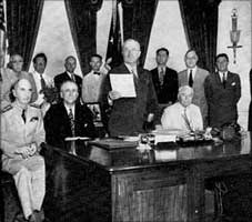 President Truman announcing the surrender of Japan.On the left can be seen Secretary Byrnes and Admiral Leahy. 